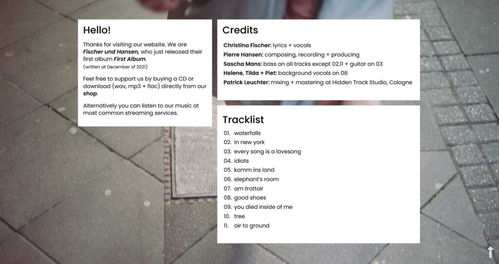 Die Website enthält eine Bandvorstellung, Credits für die Mitwirkenden am Album und eine 13-Song-Trackliste über einer unscharfen Straßenszene - erstellt mit der Expertise von Webdesign Aachen.
