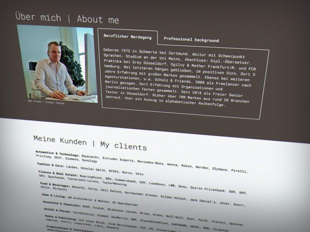 Eine zweisprachige Website-Profilseite in Deutsch und Englisch zeigt einen Mann an seinem Schreibtisch, mit Rubriken wie "Über mich", "Beruflicher Hintergrund" und "Meine Kunden". Ideal für einen Wordpress- oder Webdesign-Profi aus Aachen, mit Firmeneinträgen und einem kurzen Lebenslauf.